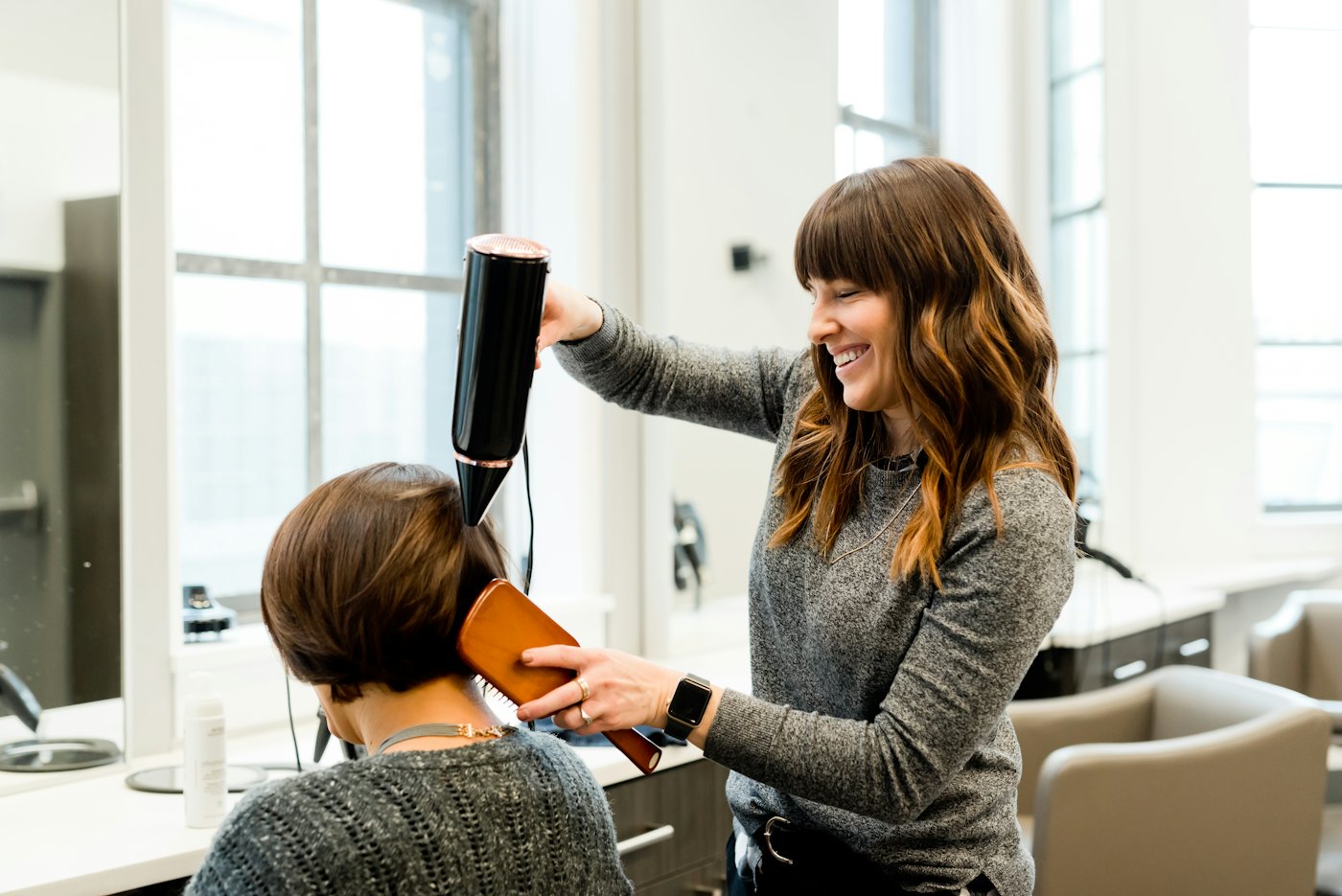 A stylist blow-drying a client's hair