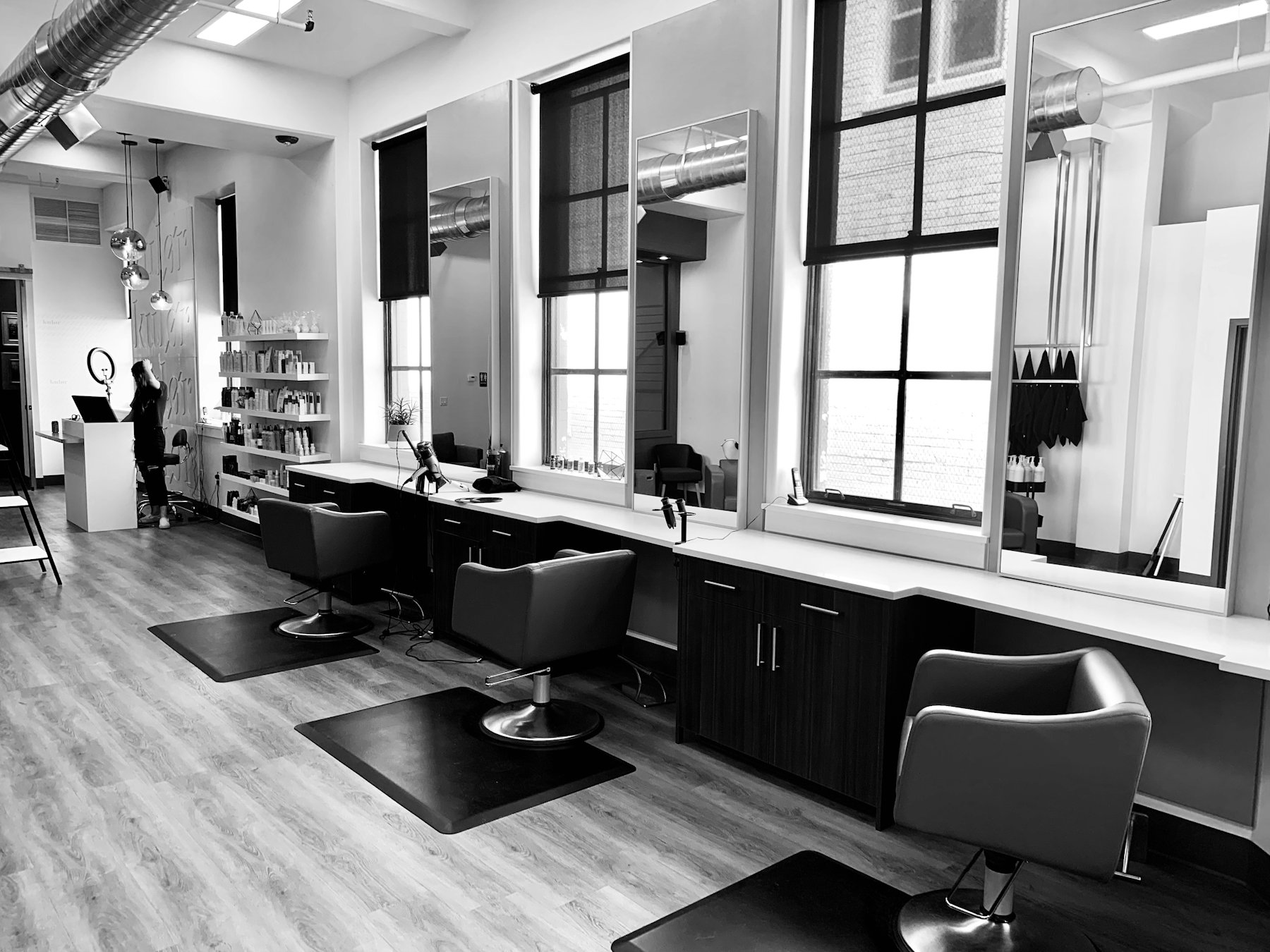Inside a bright salon with styling chairs and large windows