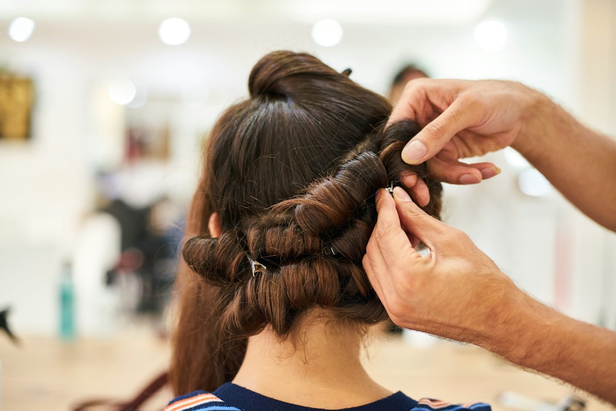 A stylist pinning an elegant updo